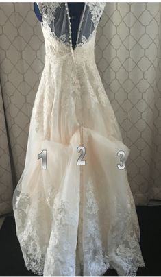 a dress that is on display in front of a curtain with the numbers 2 and 3 below it