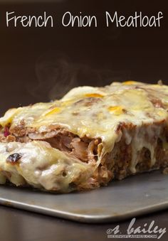 meatloaf covered in cheese and sauce sitting on a metal pan with steam rising from it