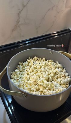 a pan filled with popcorn sitting on top of a stove