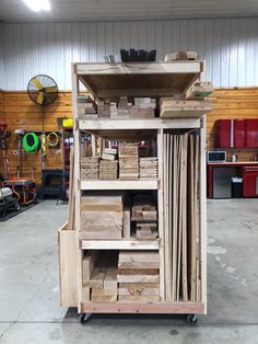 a large wooden cart filled with lots of wood planks in a garage or workshop