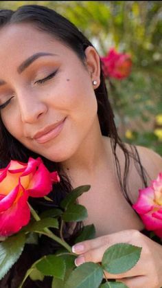 a woman with her eyes closed holding roses