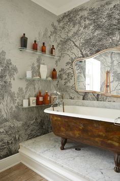 a bath tub sitting under a mirror in a bathroom