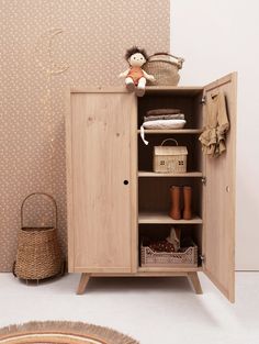 a wooden cabinet with baskets and clothes on it