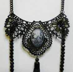 Eye catching ghostly cameo, long string of black beads to toss over your shoulder as you make your entrance to a festive Halloween party Metal lace with Cameo and 2 small black roses 13 inch neck black neck chain 14 inch drop black beaded chain 1 - 3 1/2 black tassel Gothic Black Necklace For Evening, Black Gothic Necklace For Evening, Black Witchy Necklace For Parties, Witchy Black Necklace For Parties, Goth Things, Black Cameo, Metallic Party, Black Neck, Black Roses