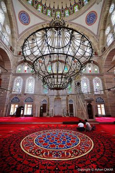 the inside of an ornate building with red carpet and chandelier hanging from the ceiling