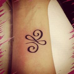 a woman's wrist tattoo with the letter g on it