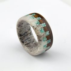 a ring made out of wood and ceramic with flowers inlays on the inside