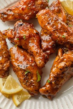 grilled chicken wings with lemon wedges on a plate