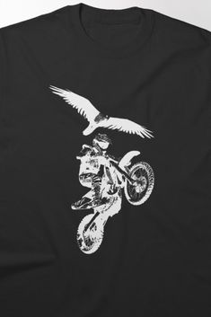 Dynamic t-shirt design featuring a motocross rider performing a jump alongside a bird of prey, perfect for dirt bike enthusiasts. This bold graphic captures the thrill of motocross with an adventurous and fierce aesthetic. Buy Dirt, Motocross Riders, Bird Of Prey, Sports Lover, Dirt Bike, Motocross, T Shirt Design, Advent, Classic T Shirts