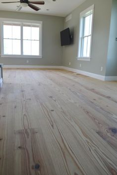 an empty living room with wood floors and ceiling fan