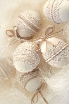 three white ornaments with twine on them