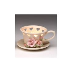 a tea cup and saucer with pink roses on the rim, decorated with hearts