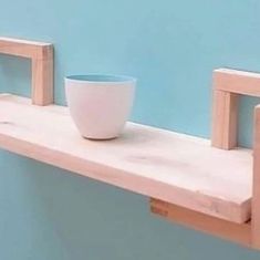 a white bowl sitting on top of a wooden shelf