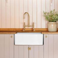 a white kitchen sink sitting under a faucet next to a wooden counter top