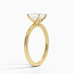 a yellow gold engagement ring with a princess cut diamond in the center, on a white background