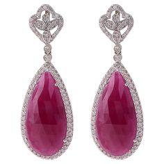 18 Karat White Gold 22.78 Carat Ruby and Diamond Drop Earrings This magnificent merlot red ruby and diamond long slice hanging earring is beautiful. The solitaire pear shaped faceted slice ruby is surrounded with a single cluster of pave set round diamonds in solid white gold, making the look more elegant. The leveled down diamond cluster brings the focus back on the ruby, as the diamonds flash through the light drawing everyone’s eyes to the earring pair. The top part of the earring consists of Elegant Ruby Diamond Earrings, Elegant Pear-shaped Ruby Jewelry, Pear-shaped Ruby Gemstone Earrings, Formal Pear-shaped Ruby Jewelry, Pear-shaped Ruby Earrings, Ruby Teardrop Earrings For Formal Occasions, Ruby Teardrop Earrings Fine Jewelry, Light Drawing, Hanging Earring