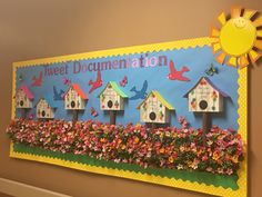 a bulletin board with bird houses and flowers