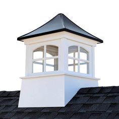 a white clock tower sitting on top of a roof