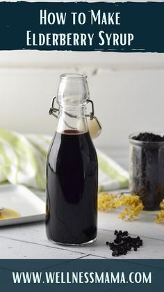 a bottle filled with elderberry syrup sitting on top of a table next to other ingredients