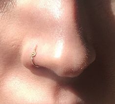 a close up of a person's nose with an earring on top of it