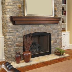 a living room with a stone fireplace and bookshelves