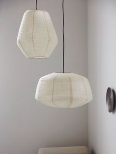 two white lamps hanging from the ceiling in a room