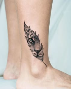 a cat's head with a feather tattoo on the ankle is shown in black and white