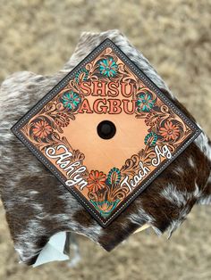 a brown and white cow hide with an orange tag on it's side that says she shu agbu