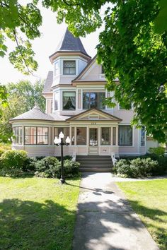 a large white house sitting on top of a lush green field