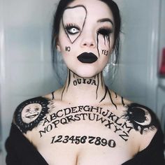 a woman with black makeup and tattoos on her face