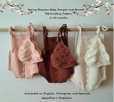 three knitted baby rompers and bonnets hanging on a clothes line with flowers in the background