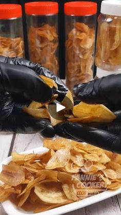 a white plate topped with lots of chips next to plastic containers filled with orange juice