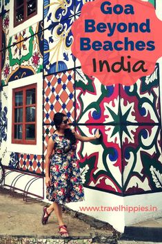 a woman standing in front of a colorful building with the words goa beyond beaches india