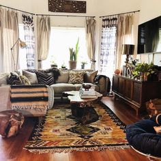 a living room filled with lots of furniture and decor on top of a hard wood floor