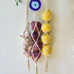 an assortment of fruits and vegetables hanging on a white wall with blue glass eyeballs