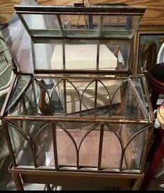 an old glass box sitting on top of a wooden table next to a fan and other items