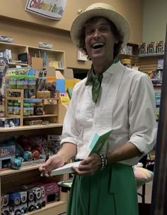 a man wearing a hat and green skirt in a store with toys on the shelves