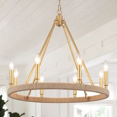 a chandelier hanging from the ceiling in a room with white walls and wood floors