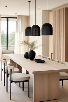 a dining room table and chairs with black vases on it's centerpiece