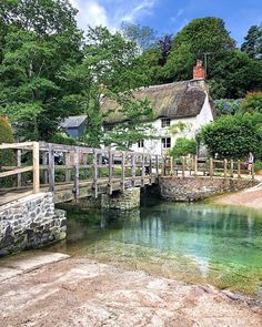 a small bridge over a river next to a house