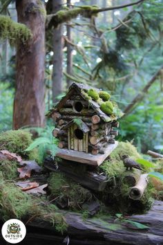 a bird house made out of logs and moss