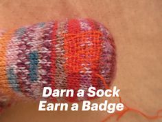 A freshly darned sock with bright orange and red colors Woodworking