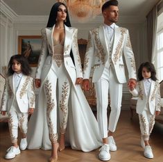 a man and woman in white suits standing next to each other with two children wearing matching outfits