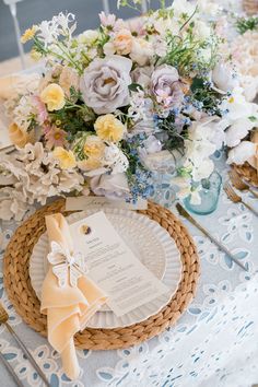 a table topped with plates and flowers on top of a table