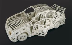 an intricately carved model of a car with skeleton parts on it's side