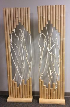 two pieces of art made out of bamboo sticks and branches with white paint on them