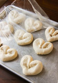 heart shaped doughnuts sitting on top of a cookie sheet