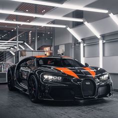 a black and orange bugatti car parked in a garage