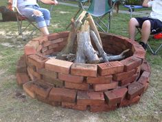 two people sitting in lawn chairs around a fire pit made out of bricks and logs