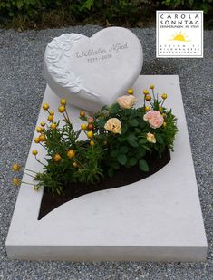 a white heart shaped planter with flowers in it